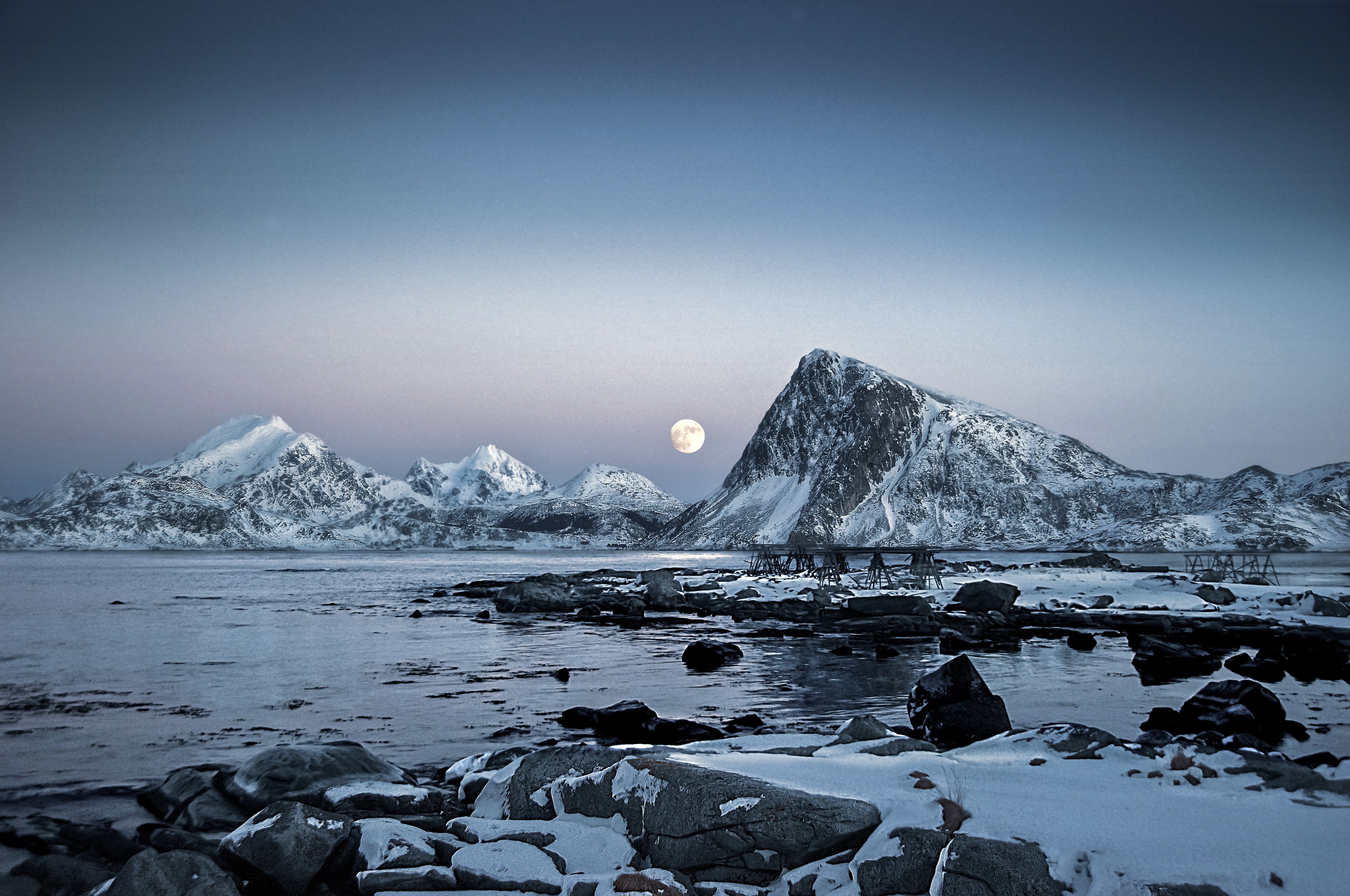 Moon over a quiet winter sea and mountain range